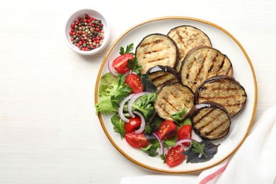 Photo of Grilled slices of eggplant with salad and peppercorns on white wooden table, top view