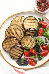 Photo of Grilled slices of eggplant with salad and peppercorns on white table, top view