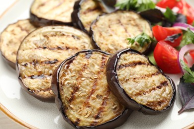 Photo of Grilled slices of eggplant with salad on white table, closeup