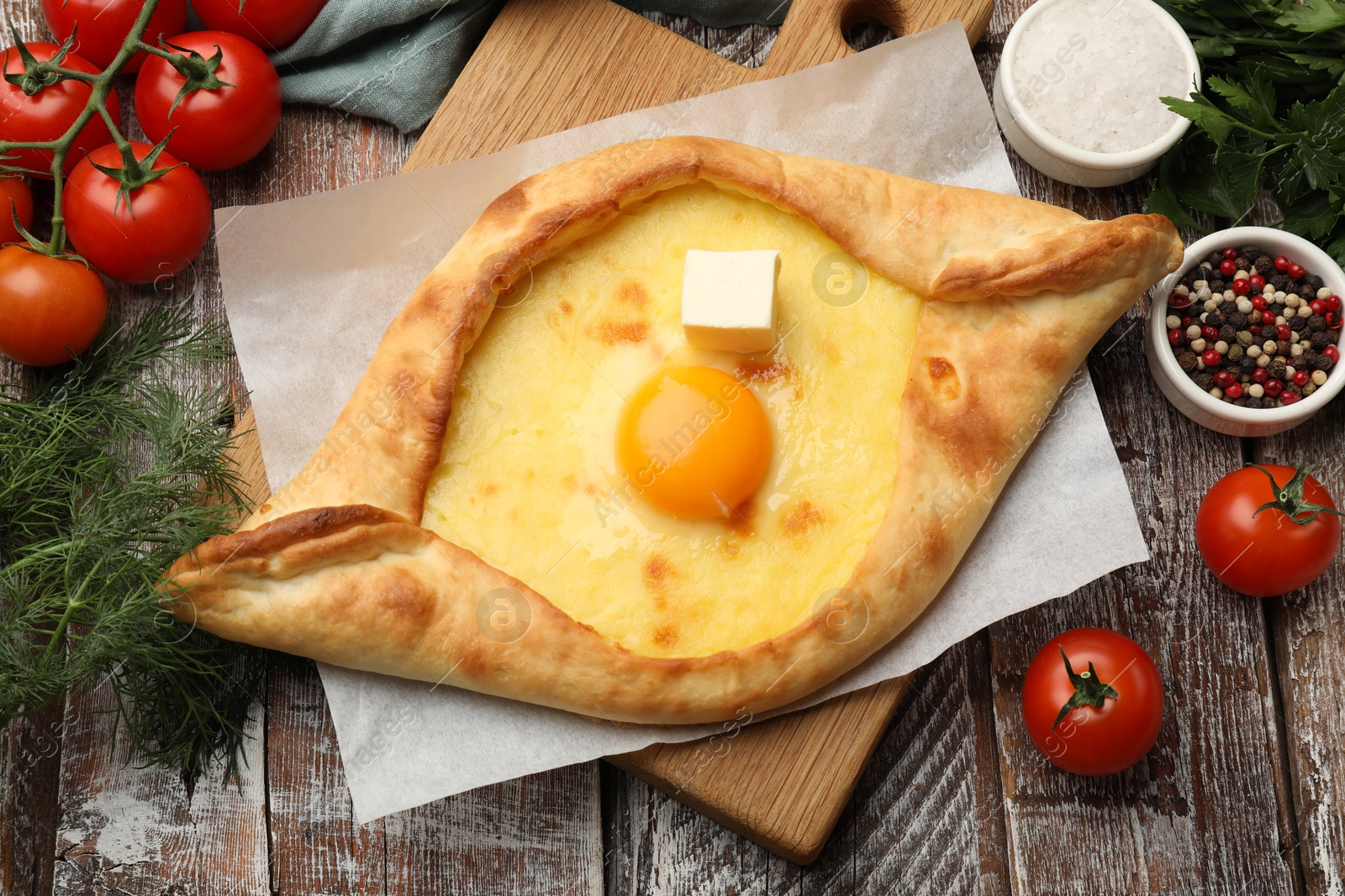 Tasty khachapuri with cheese, egg and other products on wooden table, flat lay Photo of Tasty khachapuri with cheese, egg and other products on wooden table, flat lay