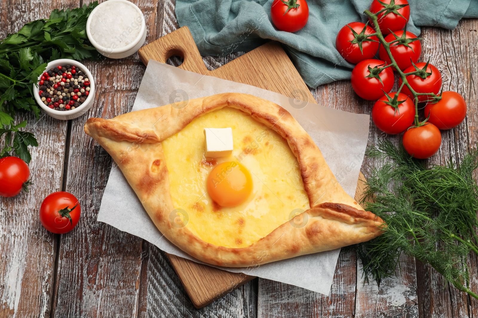 Tasty khachapuri with cheese, egg and other products on wooden table, flat lay Photo of Tasty khachapuri with cheese, egg and other products on wooden table, flat lay