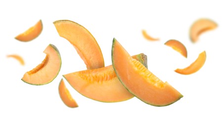 Image of Cut fresh ripe melons swirling in air against white background