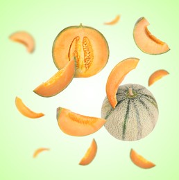 Image of Tasty ripe Cantaloupe melons swirling in air against green gradient background