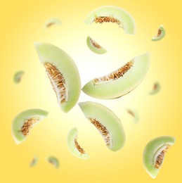 Image of Cut fresh ripe melons swirling in air against yellow gradient background