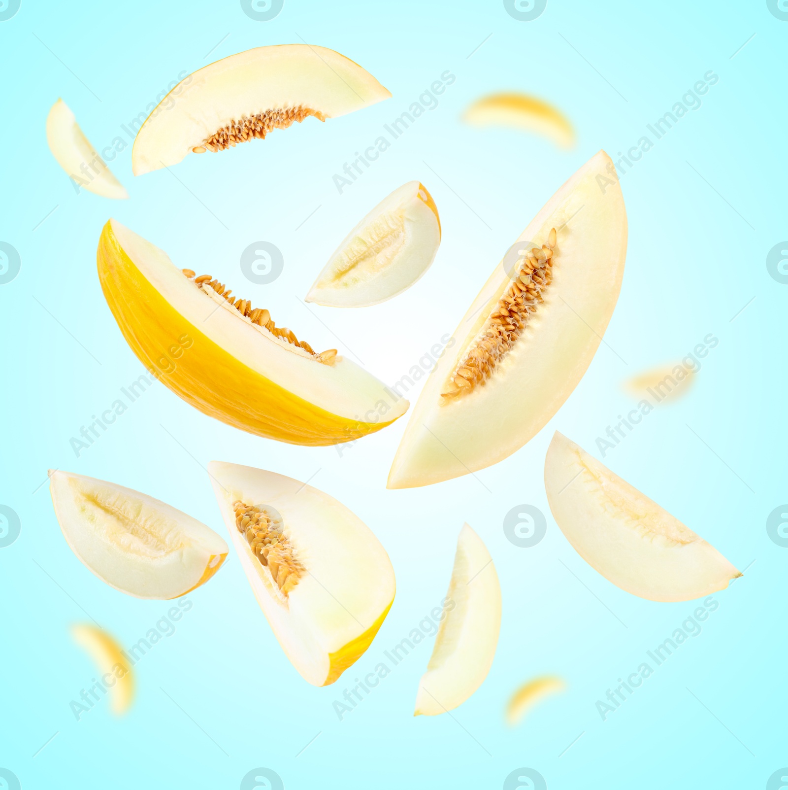 Cut fresh ripe melons swirling in air against light blue background Image of Cut fresh ripe melons swirling in air against light blue background