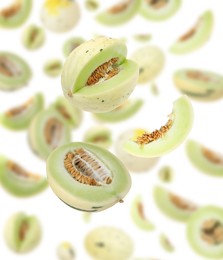Image of Cut fresh ripe melons swirling in air against white background