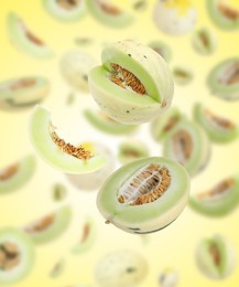 Image of Cut fresh ripe melons swirling in air against color gradient background