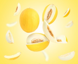 Image of Tasty ripe melons swirling in air against yellow gradient background