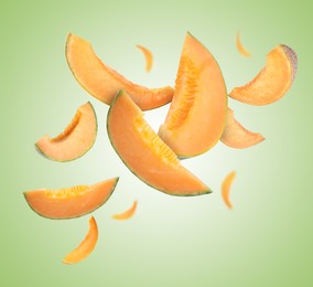 Image of Cut fresh ripe melons swirling in air against green gradient background