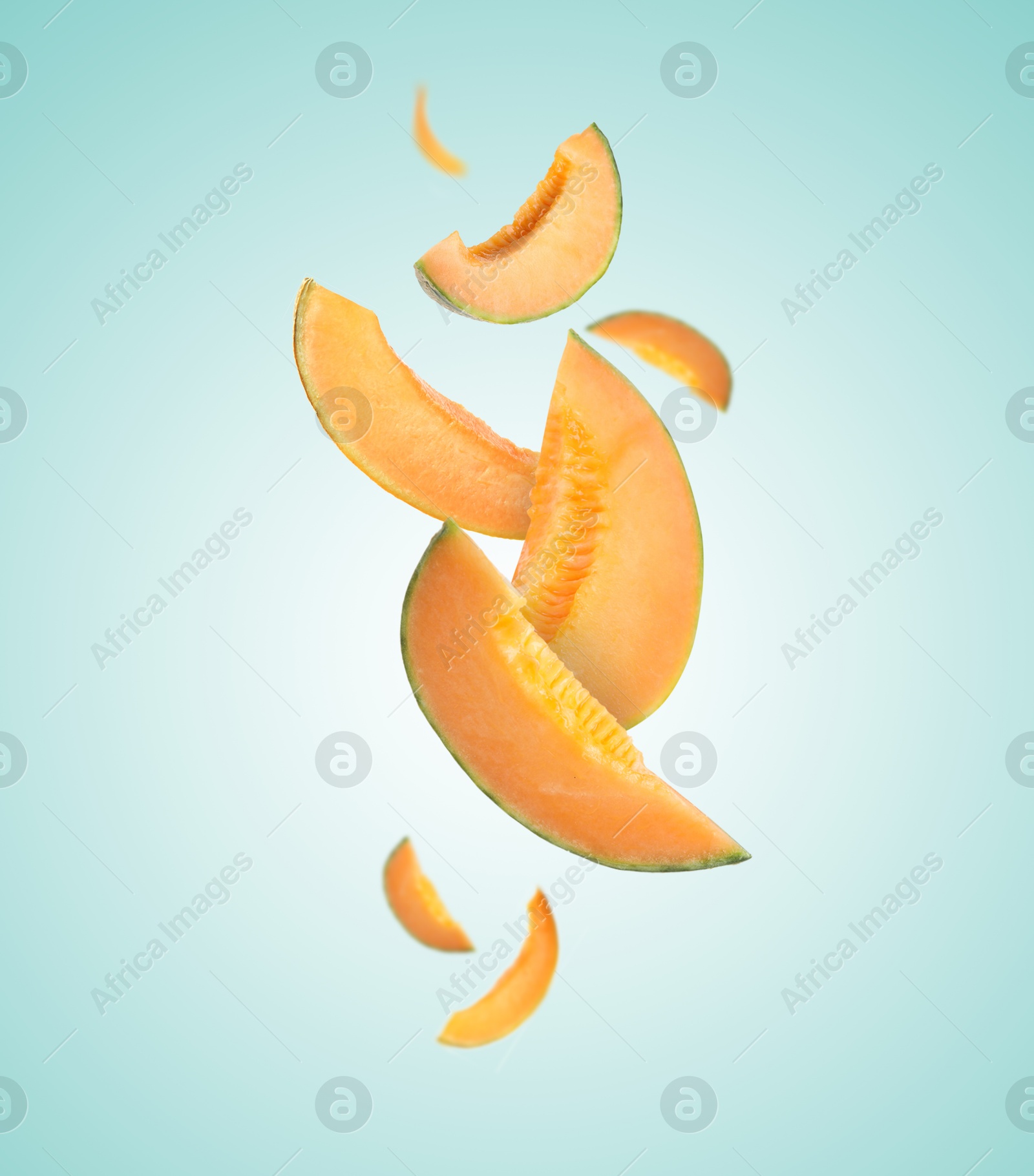 Cut fresh ripe melons swirling in air against light blue gradient background Image of Cut fresh ripe melons swirling in air against light blue gradient background