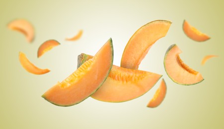 Image of Cut fresh ripe melons swirling in air against color gradient background