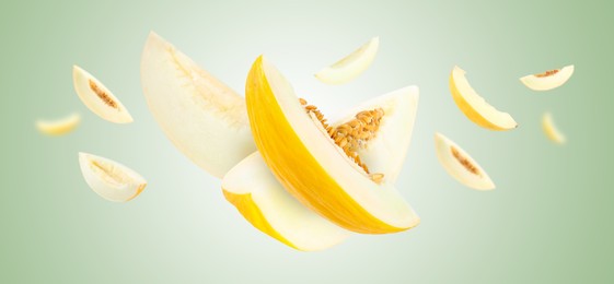 Image of Cut fresh ripe melons swirling in air against light green gradient background