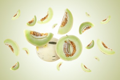 Image of Tasty ripe melons swirling in air against light green gradient background