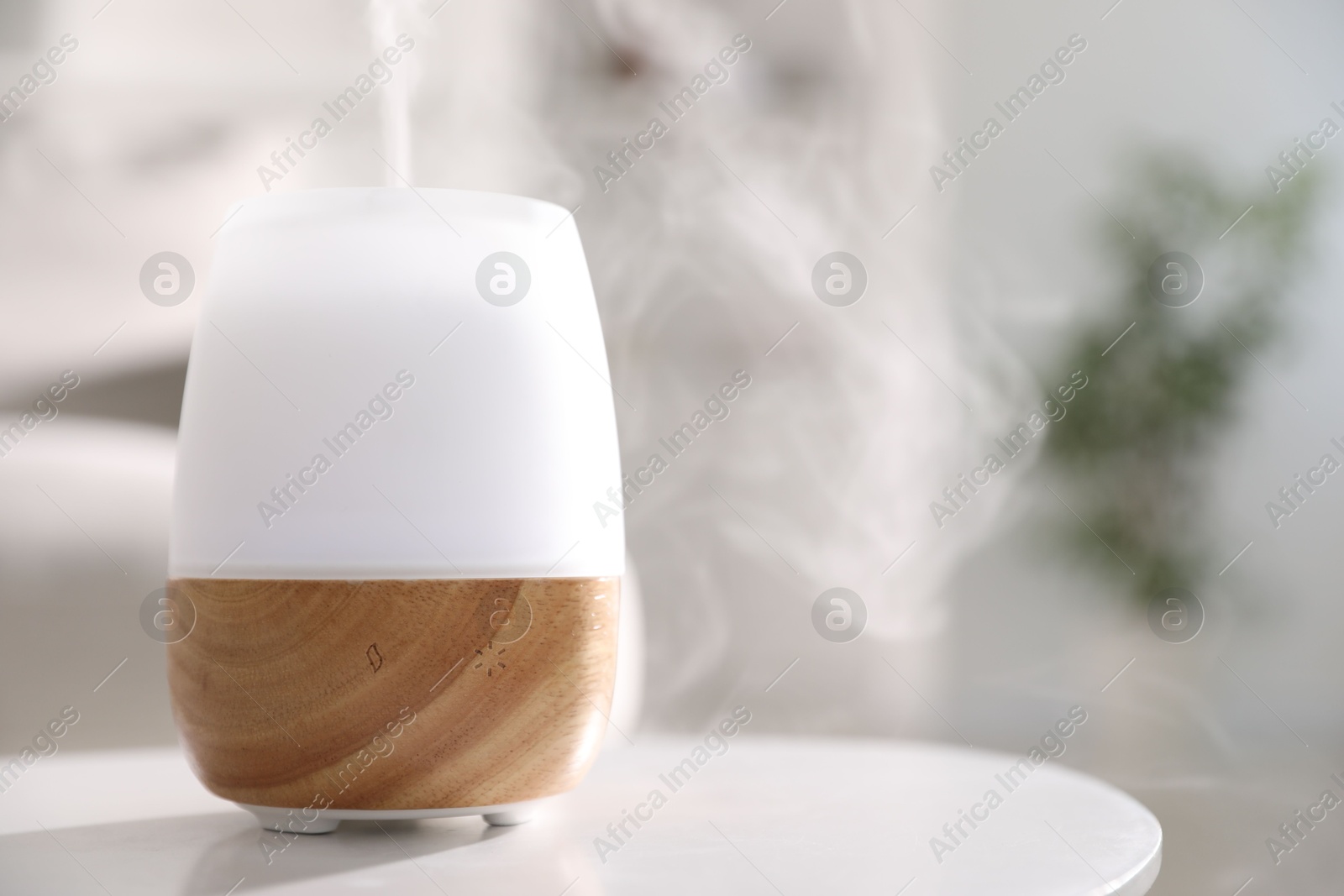 One stylish aroma lamp on white table indoors, closeup. Space for text Photo of One stylish aroma lamp on white table indoors, closeup. Space for text