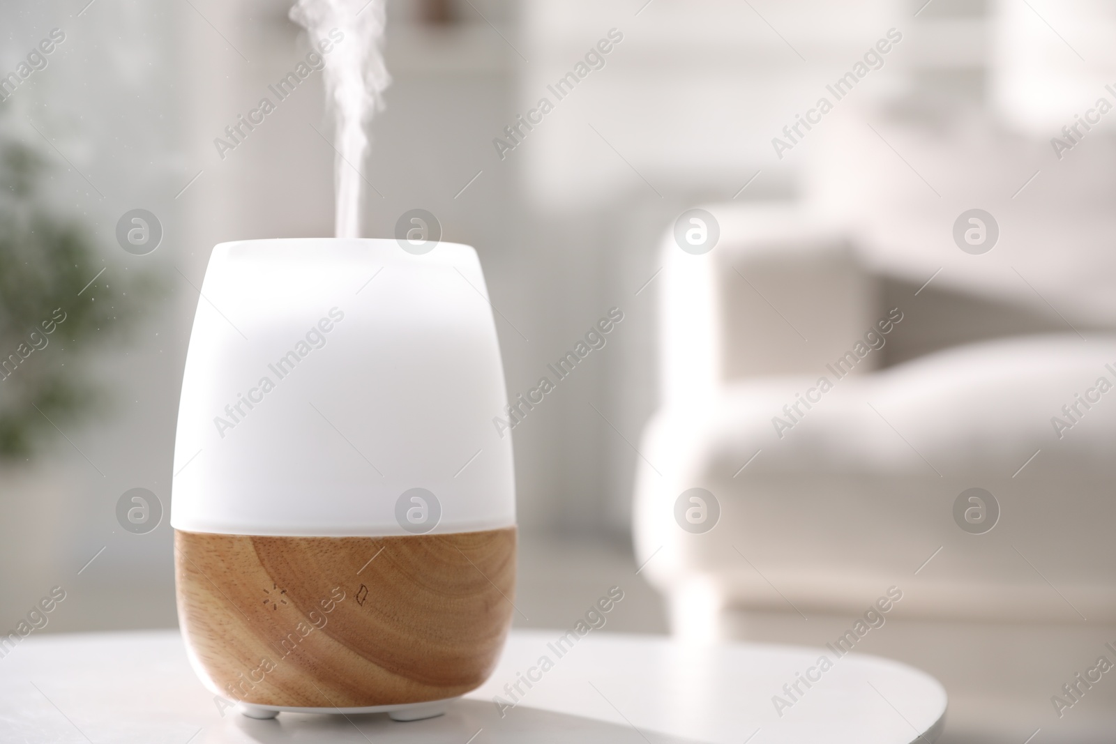 One stylish aroma lamp on white table indoors, closeup. Space for text Photo of One stylish aroma lamp on white table indoors, closeup. Space for text