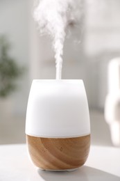 Photo of One stylish aroma lamp on white table indoors, closeup