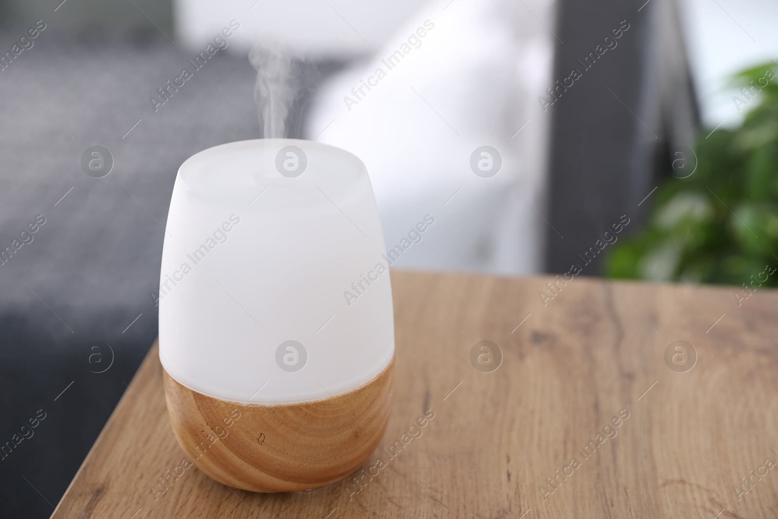 One stylish aroma lamp on wooden table indoors, closeup Photo of One stylish aroma lamp on wooden table indoors, closeup