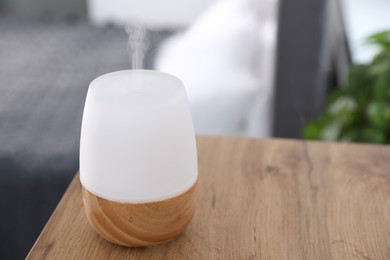 Photo of One stylish aroma lamp on wooden table indoors, closeup