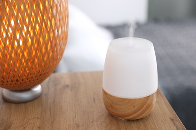 Photo of One stylish aroma lamp on wooden table indoors, closeup