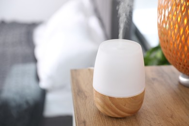 Photo of One stylish aroma lamp on wooden table indoors, closeup. Space for text