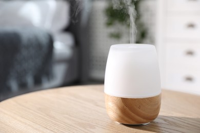 Photo of One stylish aroma lamp on wooden table indoors, closeup. Space for text