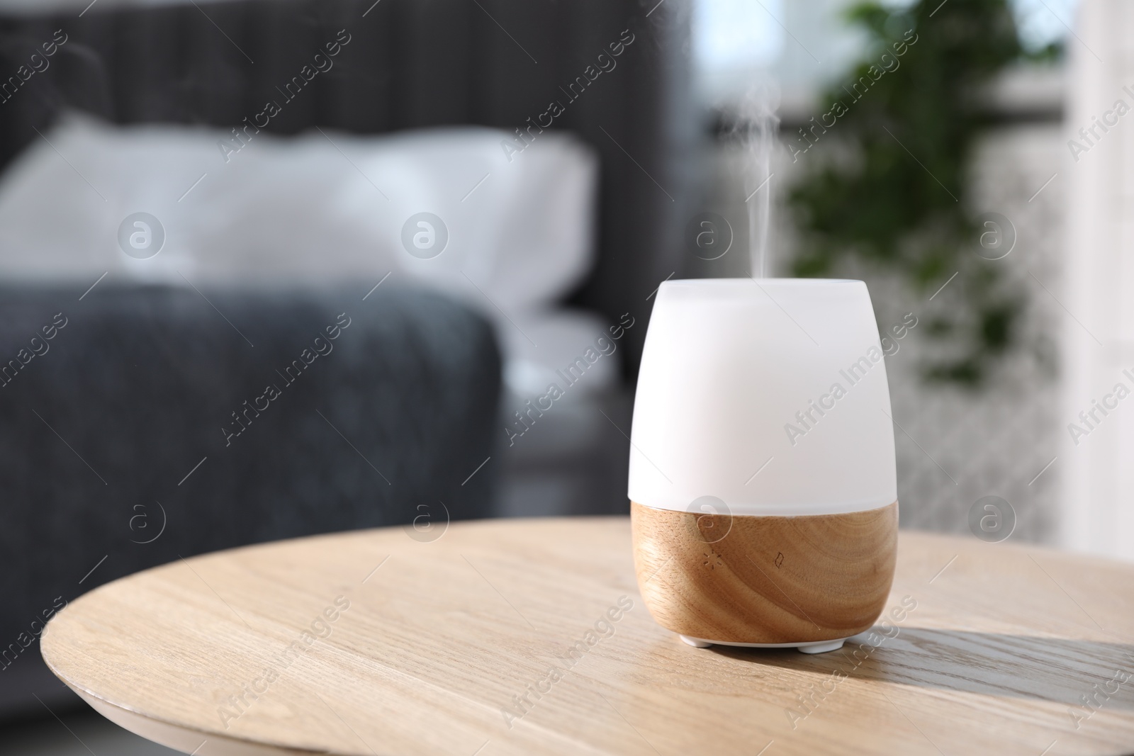 Photo of One stylish aroma lamp on wooden table indoors, closeup. Space for text