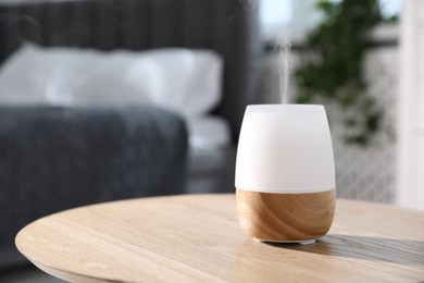 Photo of One stylish aroma lamp on wooden table indoors, closeup. Space for text