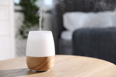 Photo of One stylish aroma lamp on wooden table indoors, closeup