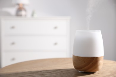 Photo of One stylish aroma lamp on wooden table indoors, closeup. Space for text