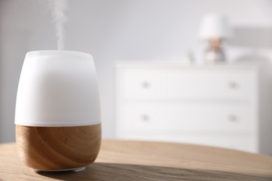 Photo of One stylish aroma lamp on wooden table indoors, closeup. Space for text