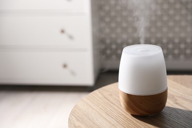 Photo of One stylish aroma lamp on wooden table indoors, closeup. Space for text