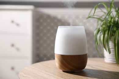 Photo of One stylish aroma lamp on wooden table indoors, closeup
