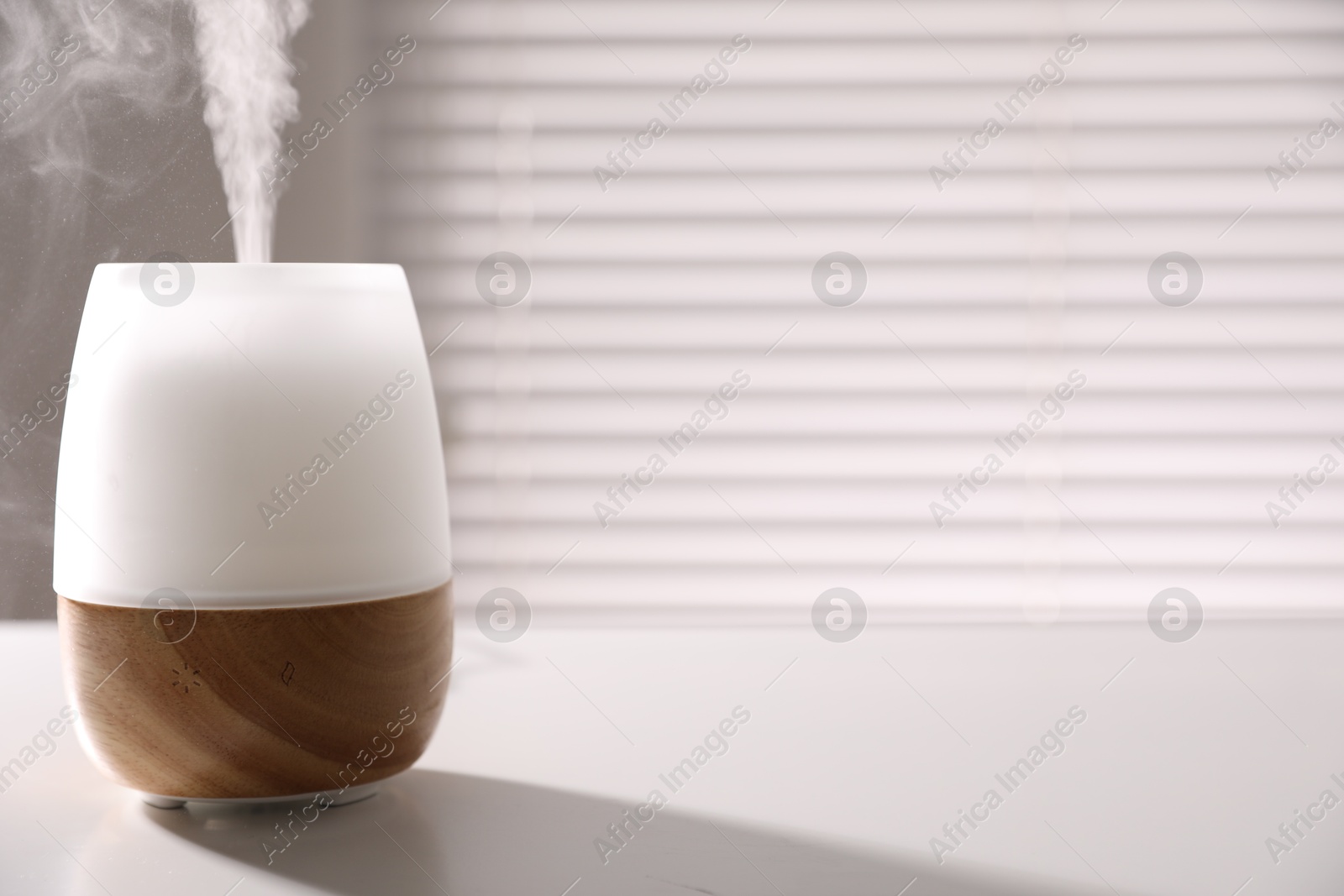 One stylish aroma lamp on white table indoors, closeup. Space for text Photo of One stylish aroma lamp on white table indoors, closeup. Space for text