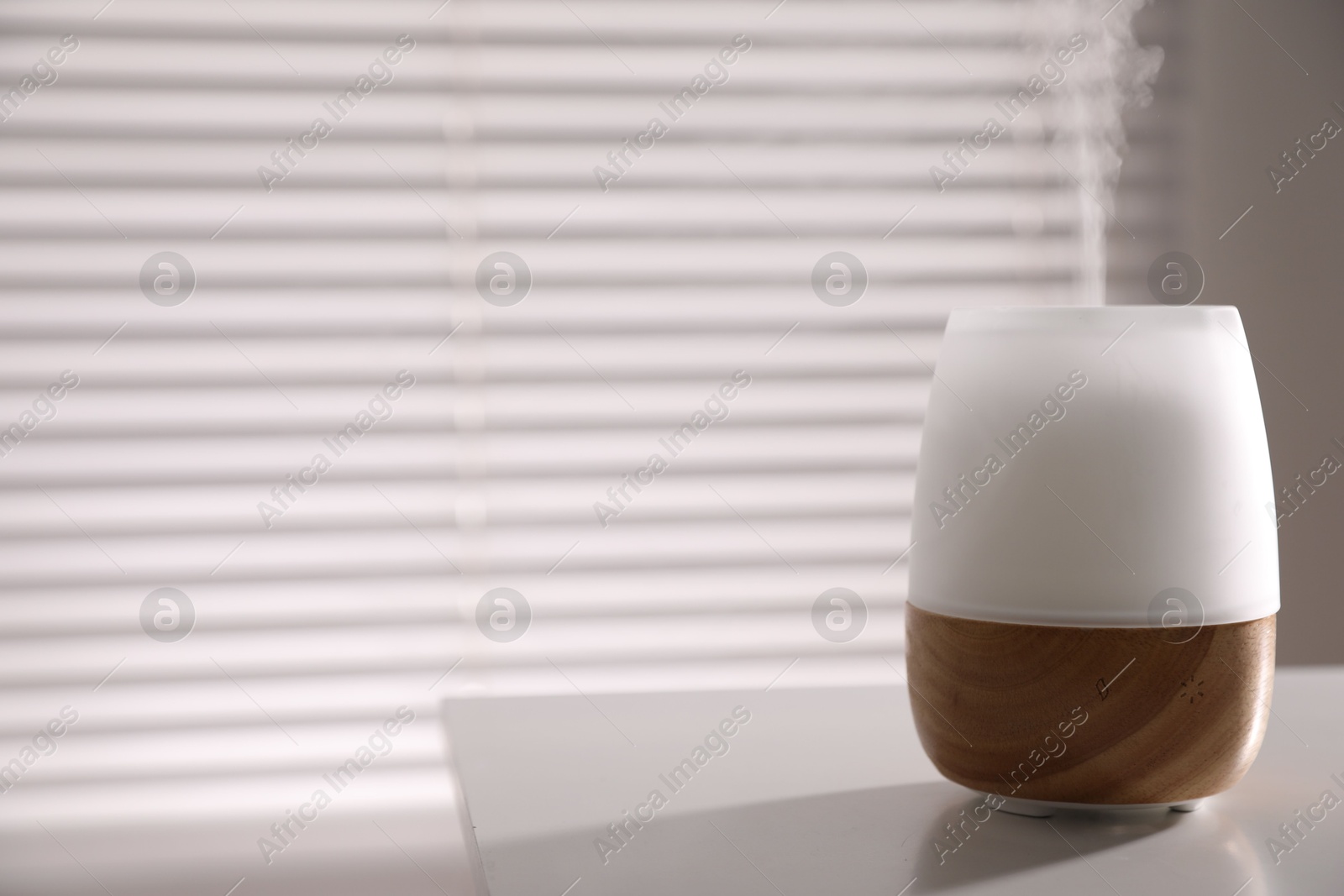 One stylish aroma lamp on white table indoors, closeup. Space for text Photo of One stylish aroma lamp on white table indoors, closeup. Space for text