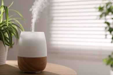 Photo of One stylish aroma lamp on wooden table indoors, closeup. Space for text