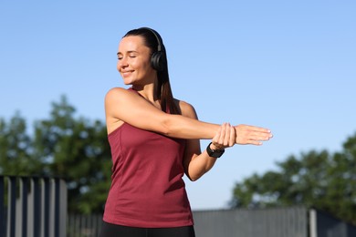 Photo of Athletic young woman with headphones before running outdoors