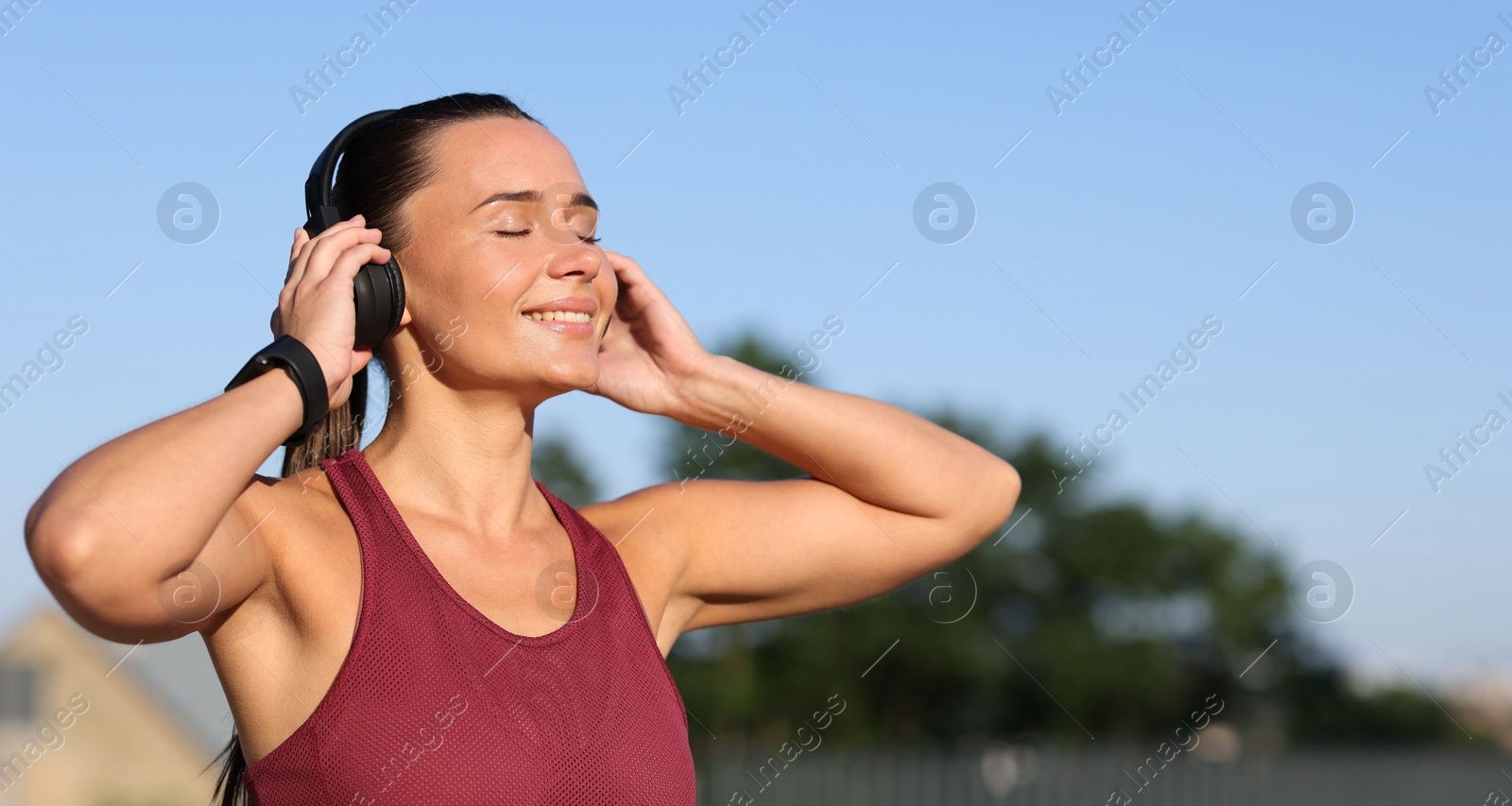Athletic young woman with headphones in sportswear before running outdoors, space for text Photo of Athletic young woman with headphones in sportswear before running outdoors, space for text
