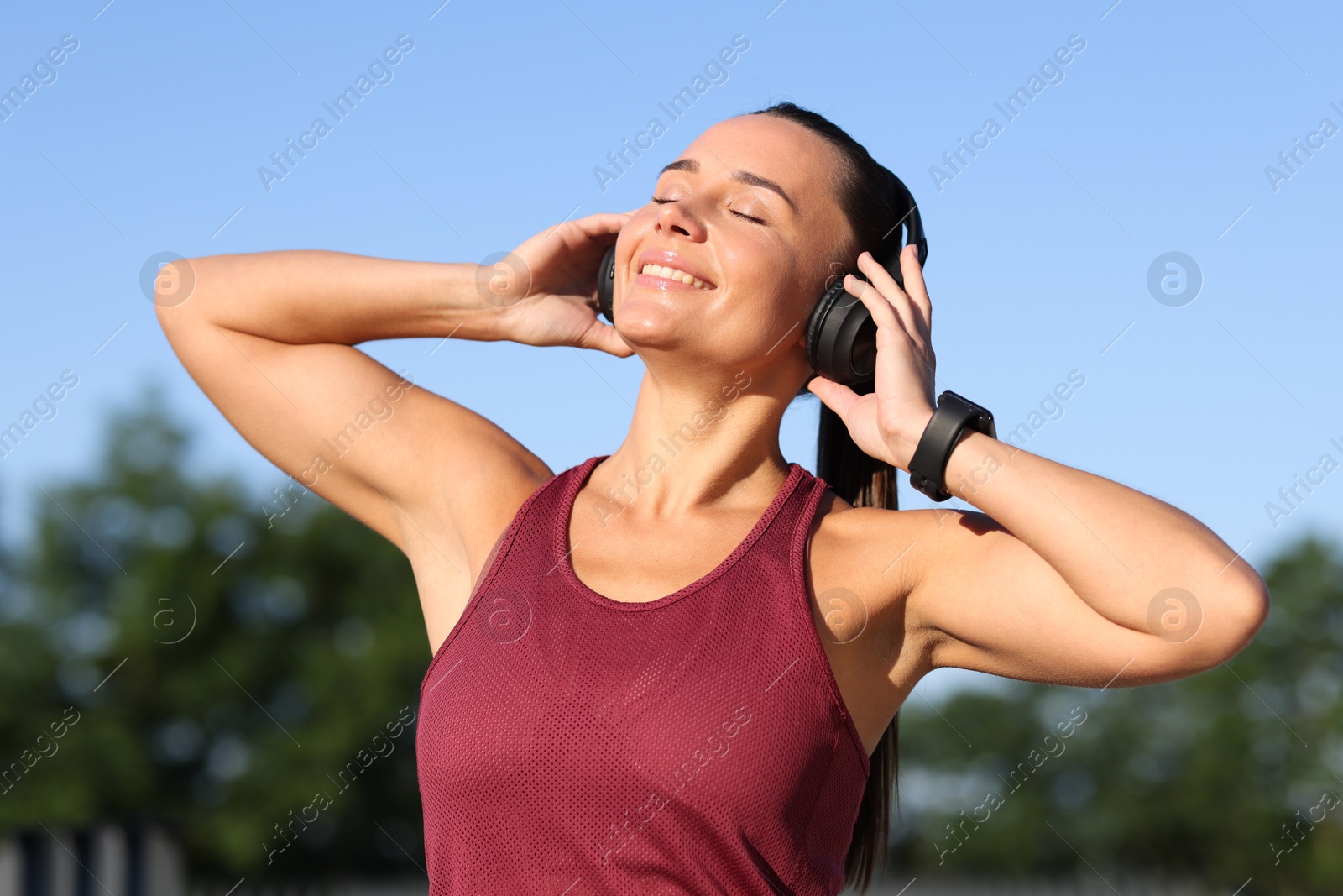 Athletic young woman with headphones in sportswear before running outdoors Photo of Athletic young woman with headphones in sportswear before running outdoors