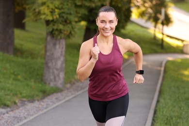 Photo of Athletic young woman in sportswear running outdoors, space for text
