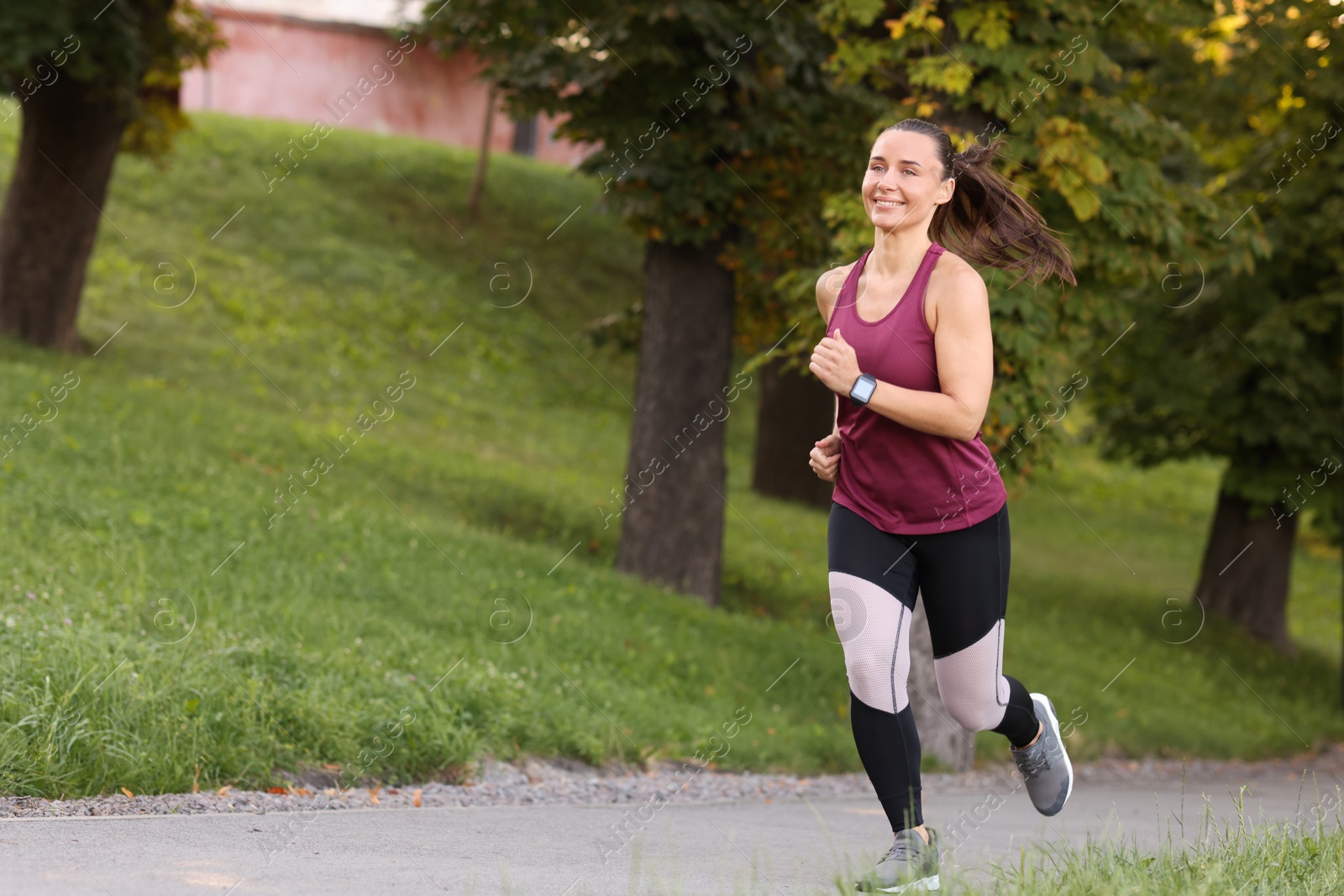 Athletic young woman in sportswear running outdoors, space for text Photo of Athletic young woman in sportswear running outdoors, space for text