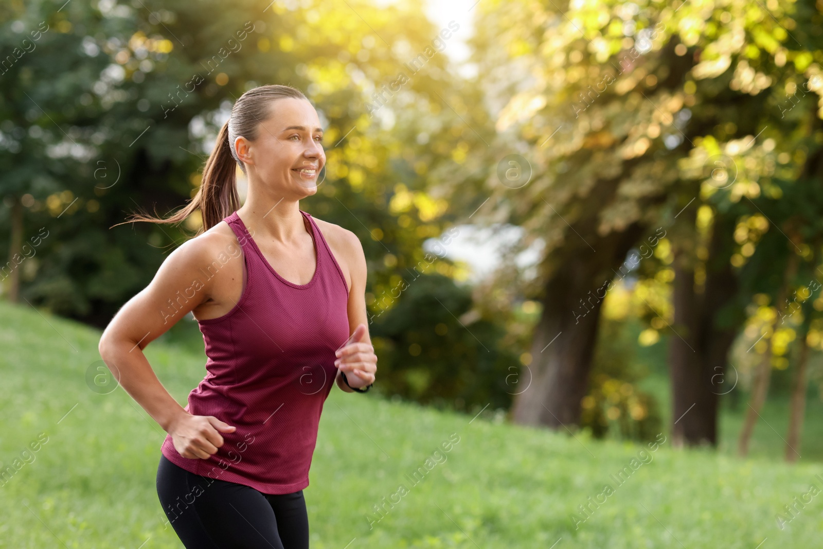 Athletic young woman in sportswear running outdoors, space for text Photo of Athletic young woman in sportswear running outdoors, space for text