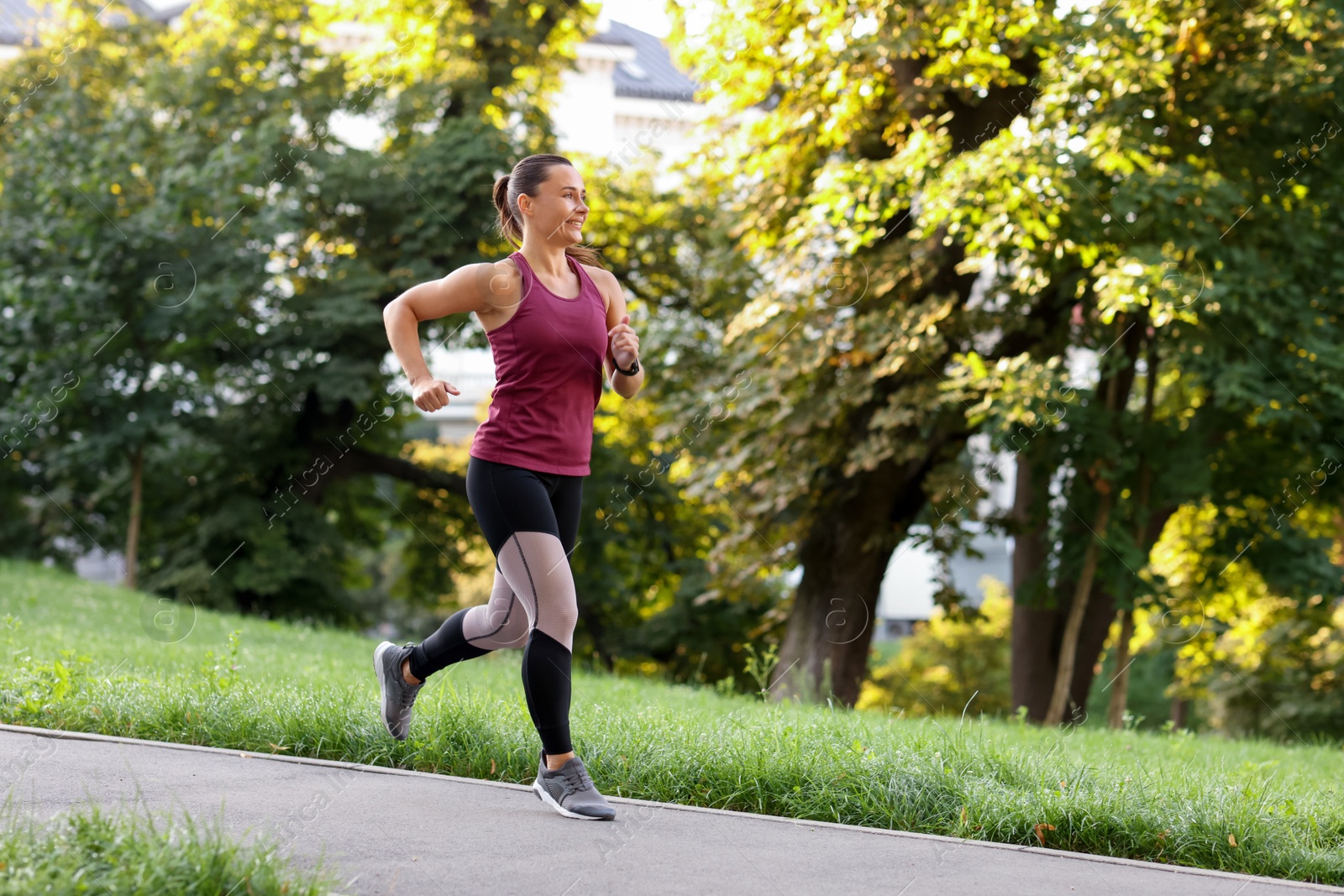 Athletic young woman in sportswear running outdoors, space for text Photo of Athletic young woman in sportswear running outdoors, space for text