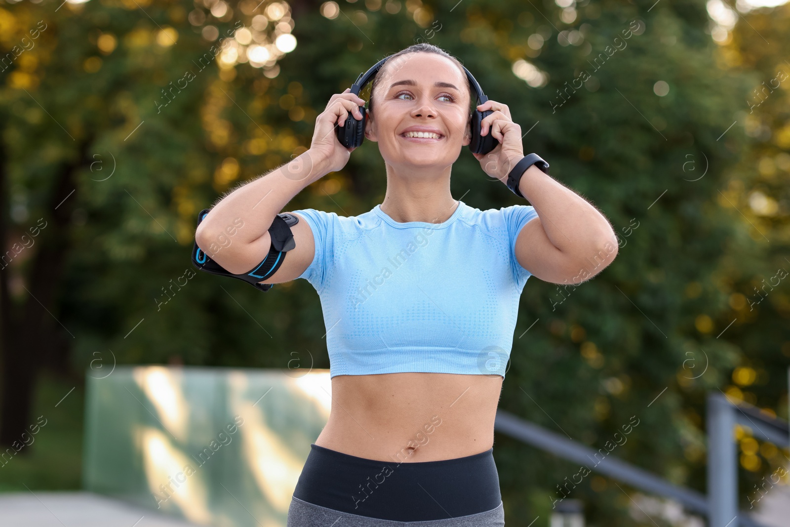 Athletic young woman with headphones in sportswear before running outdoors Photo of Athletic young woman with headphones in sportswear before running outdoors
