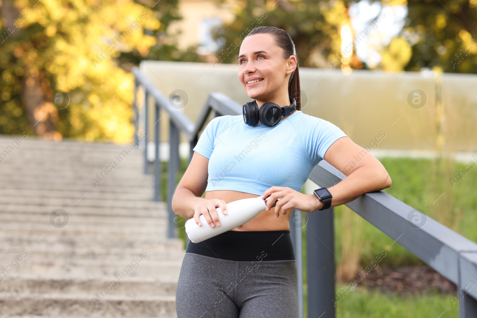 Athletic young woman with headphones in sportswear before running outdoors Photo of Athletic young woman with headphones in sportswear before running outdoors