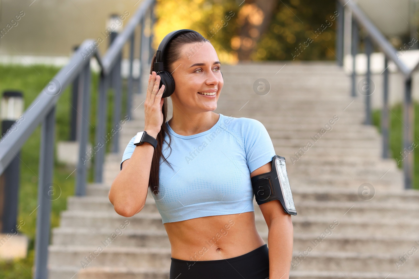 Athletic young woman with headphones in sportswear before running outdoors Photo of Athletic young woman with headphones in sportswear before running outdoors