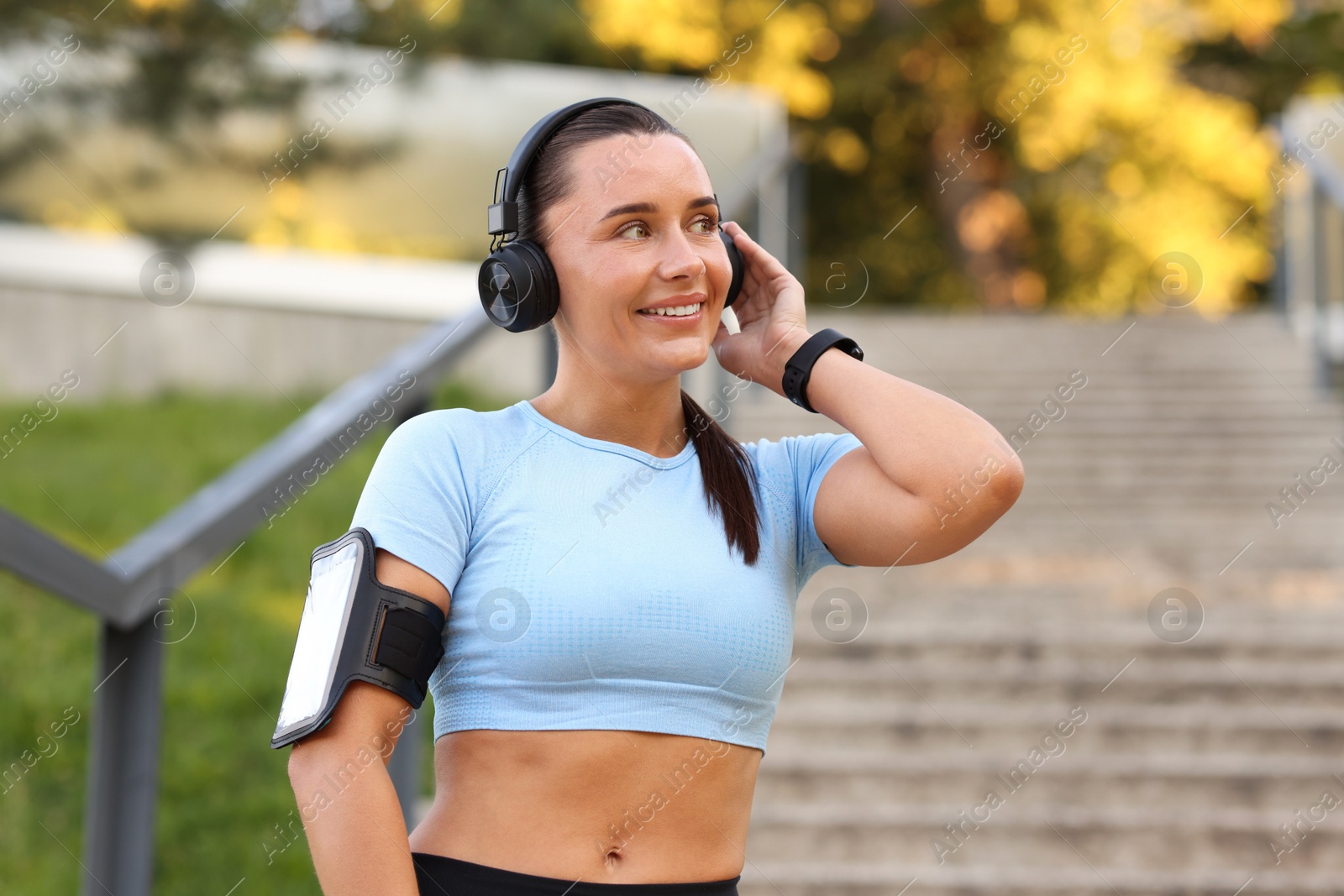 Athletic young woman with headphones in sportswear before running outdoors Photo of Athletic young woman with headphones in sportswear before running outdoors
