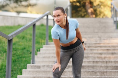 Photo of Athletic young woman in sportswear before running outdoors