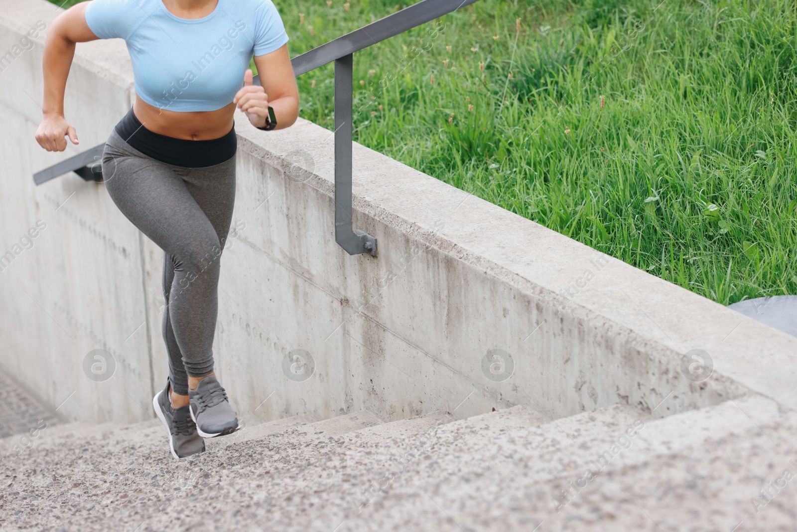 Woman in sportswear running up on stairs outdoors, closeup. Space for text Photo of Woman in sportswear running up on stairs outdoors, closeup. Space for text