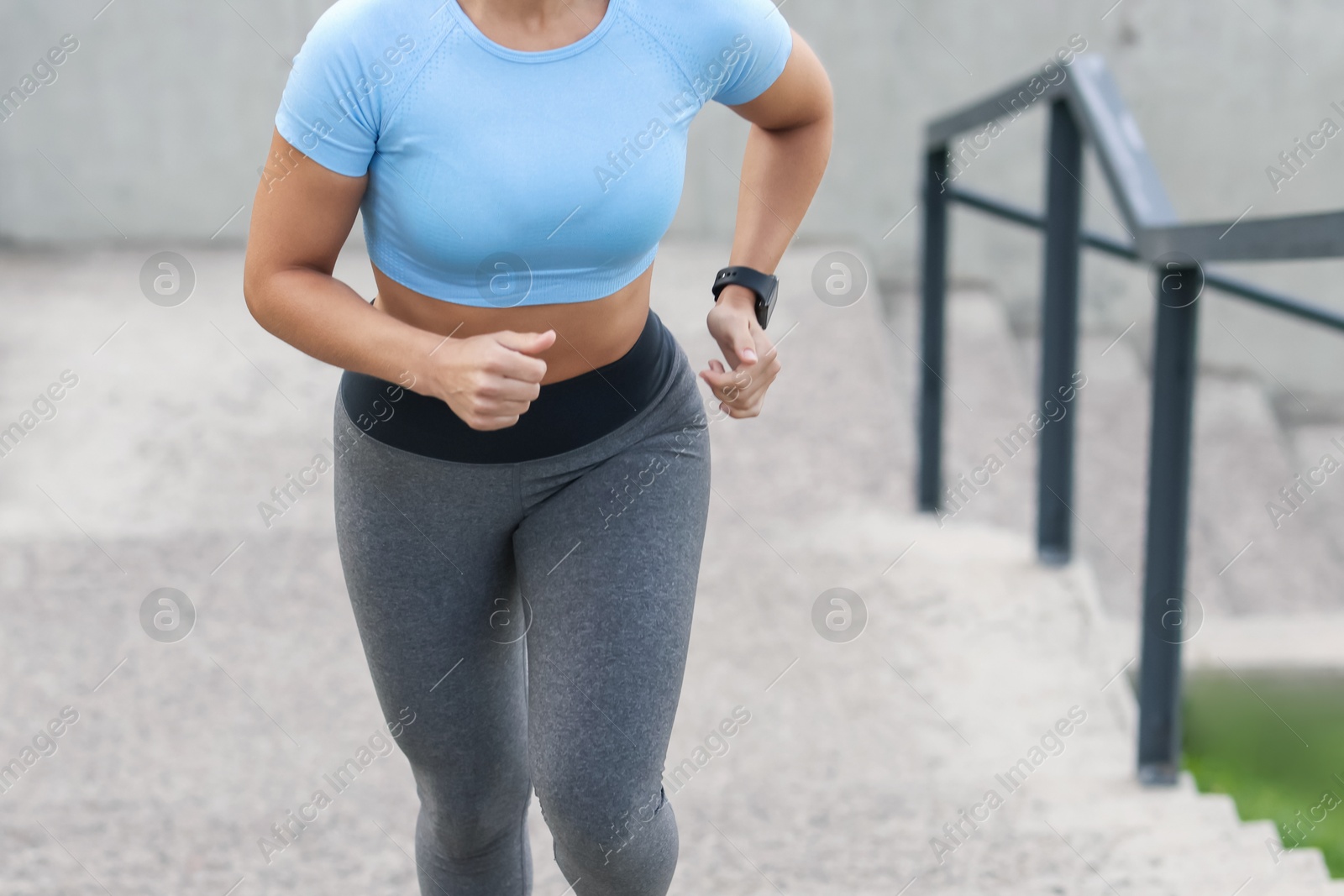 Woman in sportswear running up on stairs outdoors, closeup Photo of Woman in sportswear running up on stairs outdoors, closeup