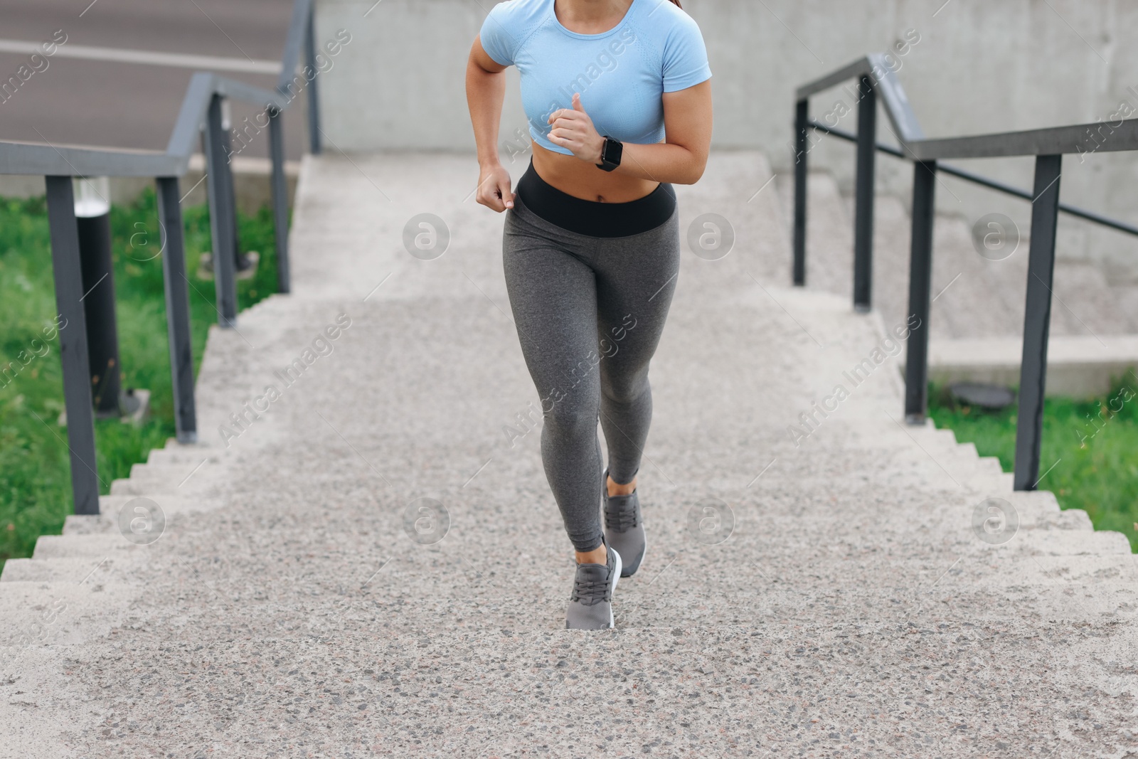 Woman in sportswear running up on stairs outdoors, closeup Photo of Woman in sportswear running up on stairs outdoors, closeup